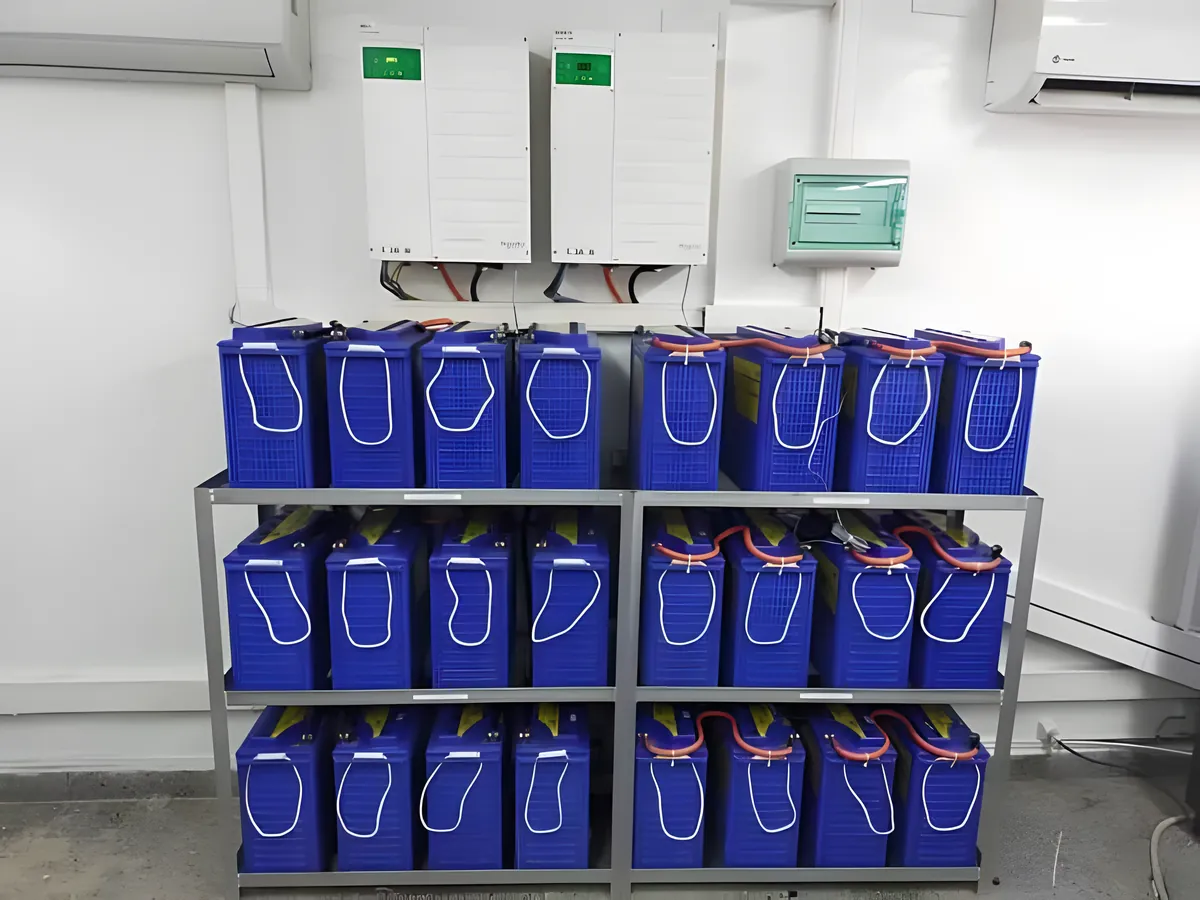 Two wall inverters above three rows of blue batteries
