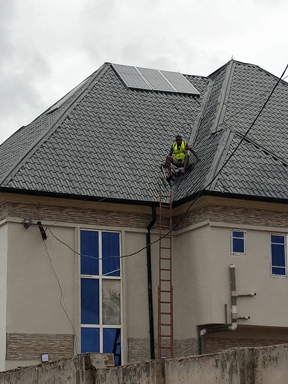 Installer on a stone-coated roof fixing solar panels